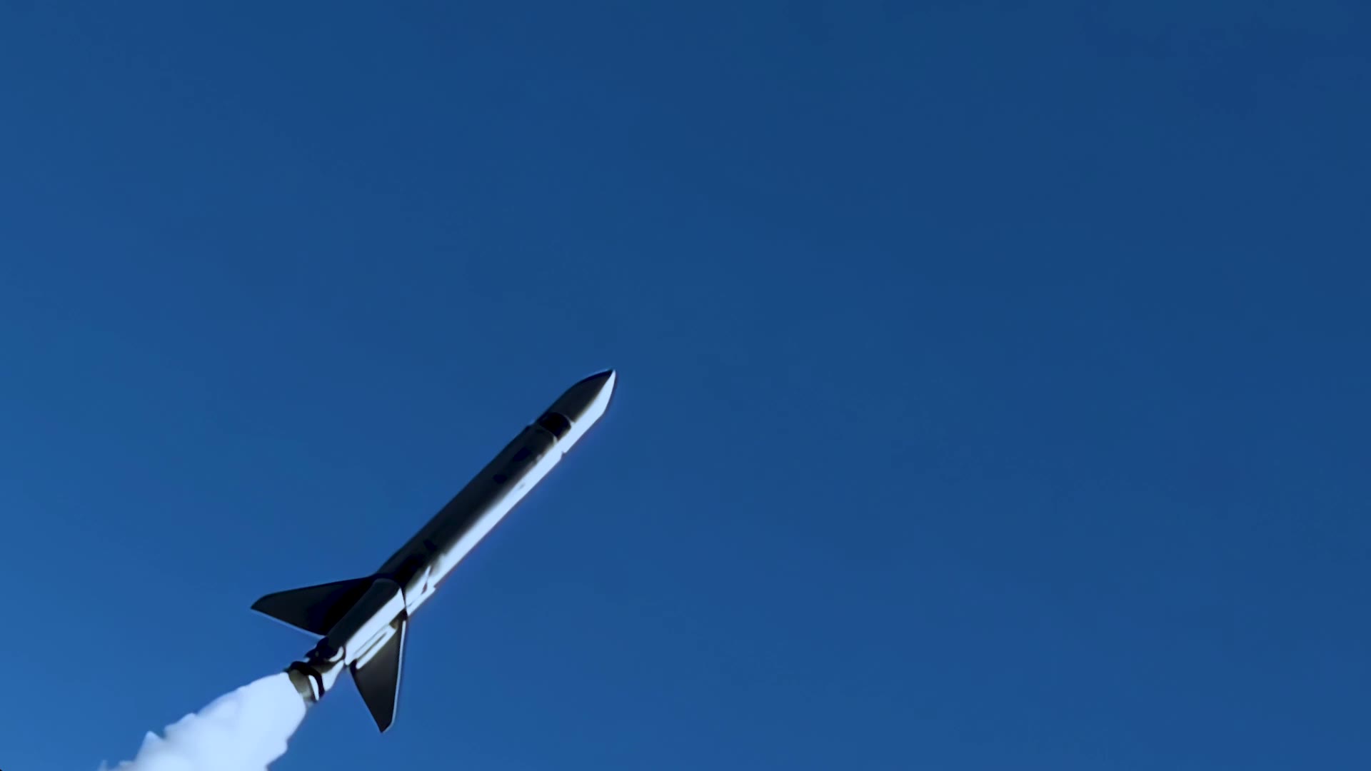 Rocket launching into a clear blue sky